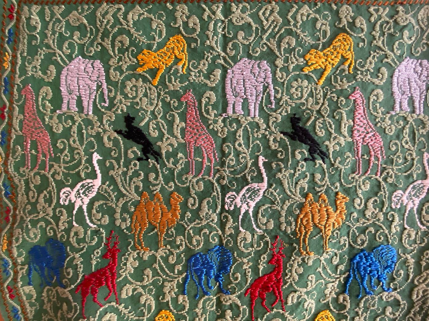 Tessuto verde con elefanti, giraffe, aironi, cervi e uccelli in tanti colori